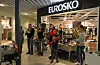 Trombonar, saksofon og baryton spela utanfor skobutikken