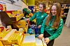 Stina Grønfur (nærmast) og Camilla Håland jobbar dugnad for fotballaget ved å rydde og hjelpe handlande med å pakke varar på Rema 1000.