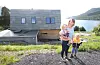 Rannveig Obrestad med Thea (2) og Vemund (4) på oppsida av huset på Årak. Skiferen er blikkfanget.