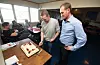 Martin Fitje (t.v.) og dagleg leiar Lars Hovda og resten av dei SMV-tilsette feira storkontrakten med kake.FOTO: TORSTEIN NYMOEN