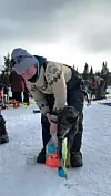 Anna Rødne Gjerde gjer ein hund klar til Gausdal Maraton.