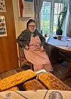 Bjørg er den eldste bebuaren og fylte nett 80 år. Ho hjelper framleis til med matlaging om føremiddagen og i vevstova om ettermiddagen. Her heldt ho oppsyn med brødbakinga i Lars Hertevigs hus. Foto: Heidi Molstad Andresen / NPK